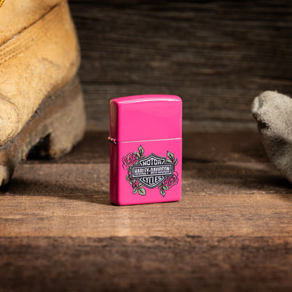 Lifestyle image of Zippo Harley-DavidsonÂ® Roses Frequency Windproof Lighter standing on a wooden floor with a work boot and glove sitting on either side.